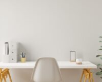 Bureau blanc moderne et épuré avec fournitures de bureau, chaise design et plante verte