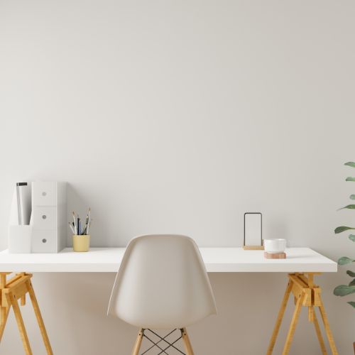 Bureau blanc moderne et épuré avec fournitures de bureau, chaise design et plante verte